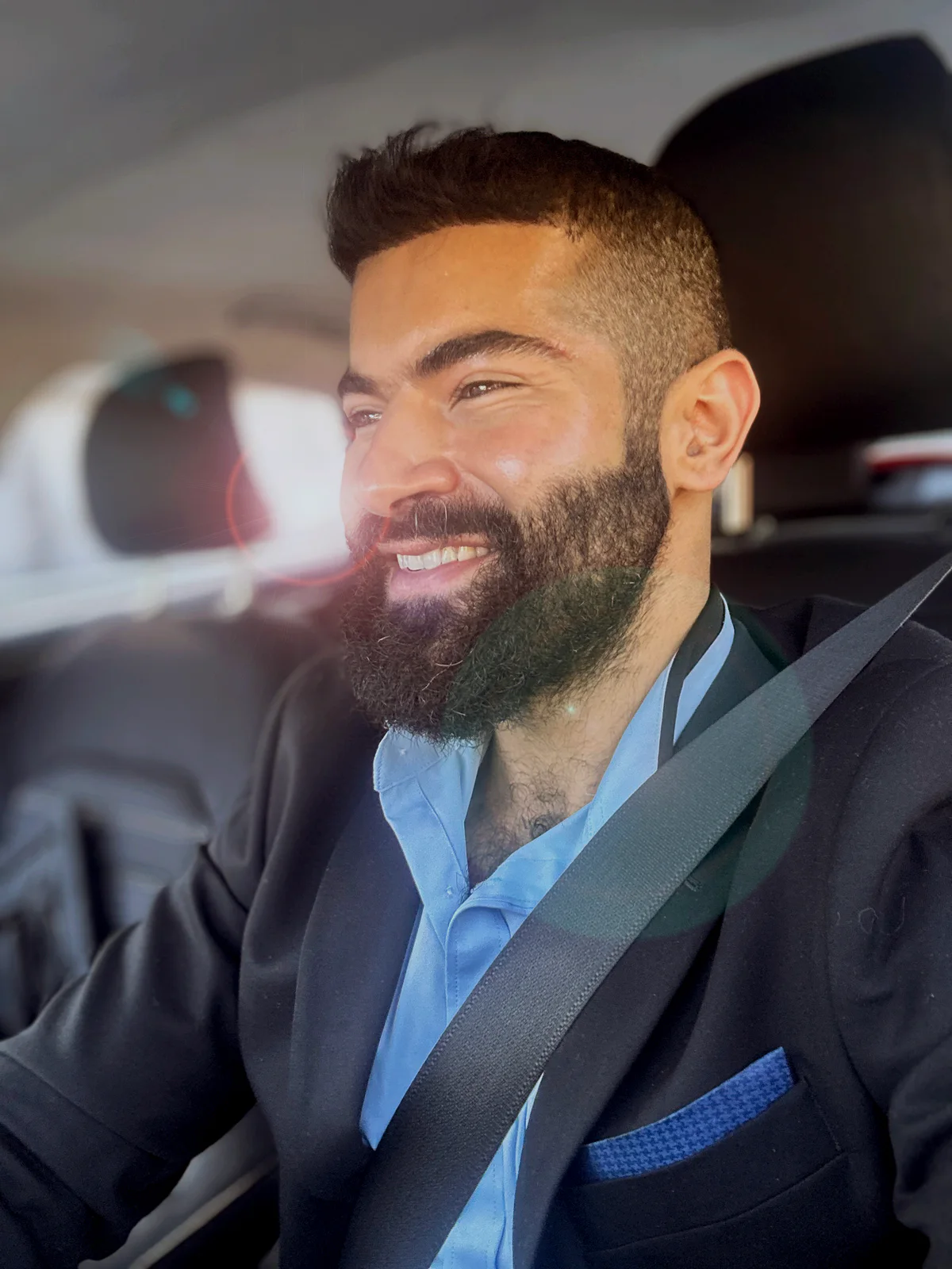 Next Move Care founder Ali T. Harris smiling in a blue shirt and black blazer